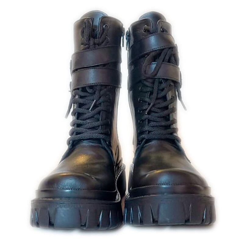 K&ouml;nnte beinhalten: Ein Paar schwarze Kampfstiefel mit dicken Sohlen. Die Stiefel haben Schn&uuml;rsenkel, Riemen mit Schnallen und einen seitlichen Rei&szlig;verschluss. Sie bestehen aus einem gl&auml;nzenden, lederartigen Material, vor wei&szlig;em Hintergrund.