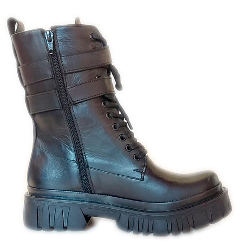 K&ouml;nnte beinhalten: Schwarzer Leder-Combat-Stiefel mit klobiger Profilsohle. Der Stiefel hat einen seitlichen Rei&szlig;verschluss, eine Schn&uuml;rung und zwei verstellbare Schnallenriemen. Er hat eine runde Spitze und eine Zuglasche am oberen Schaft.