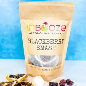 May include: A brown paper pouch with a clear window showing a tea bag inside. The pouch has the text "inBooze ALCOHOL INFUSION KIT BLACKBERRY SMASH" printed on it. The pouch also has the text "EACH INFUSION MAKES 8-10 COCKTAILS" and "NET WT 1.7 OZ (48g)" printed on it.