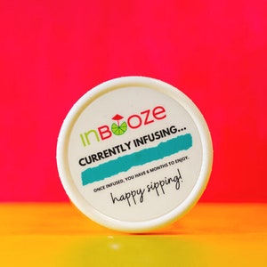 Puede incluir: Tarro blanco con tapa blanca y una etiqueta verde y azul que dice "InBooze CURRENTLY INFUSING... ONCE INFUSED, YOU HAVE 6 MONTHS TO ENJOY. happy sipping!"