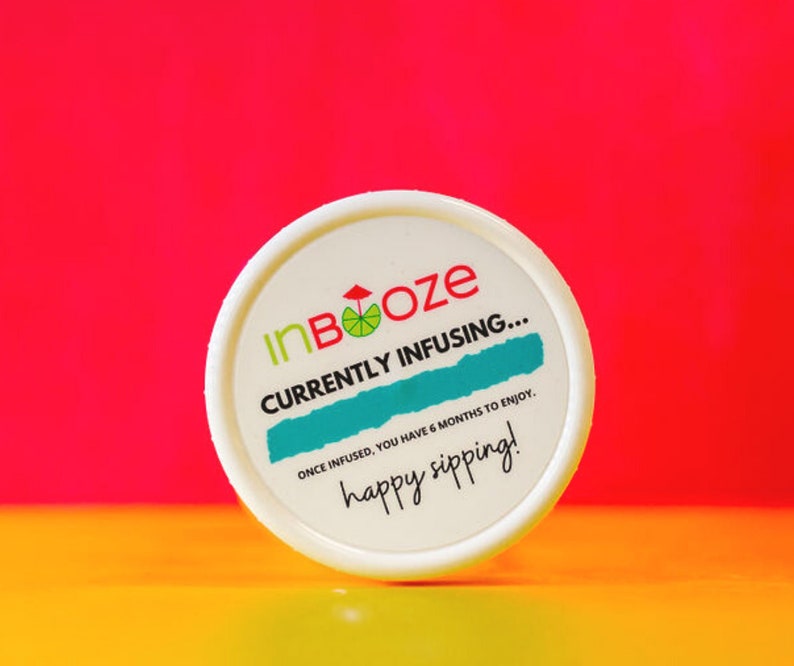 Puede incluir: Tarro blanco con tapa blanca y una etiqueta verde y azul que dice "InBooze CURRENTLY INFUSING... ONCE INFUSED, YOU HAVE 6 MONTHS TO ENJOY. happy sipping!"
