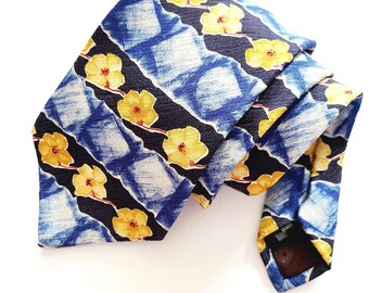 May include: A blue and black silk tie with a yellow floral pattern. The tie has a striped design with a repeating pattern of yellow flowers on a blue and black background.