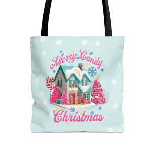 May include: A light blue tote bag with a black handle. The bag features a whimsical Christmas scene with a candy house, pink trees, and the text "Merry Candy Christmas" in pink and white.