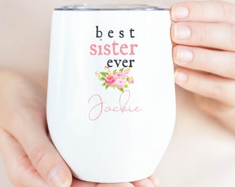 May include: White stainless steel wine tumbler with a floral design and the text "best sister ever" and the name "Jackie" in cursive.