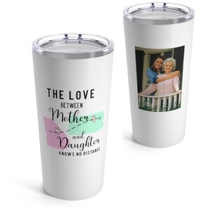 May include: White stainless steel tumbler with a black and pink design that says "The love between mother and daughter knows no distance". A photo of two women is on the other side of the tumbler.
