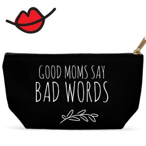 Puede incluir: Bolsa de lona negra con cremallera con texto blanco que dice "Good Moms Say Bad Words" y un peque&ntilde;o dise&ntilde;o floral blanco.