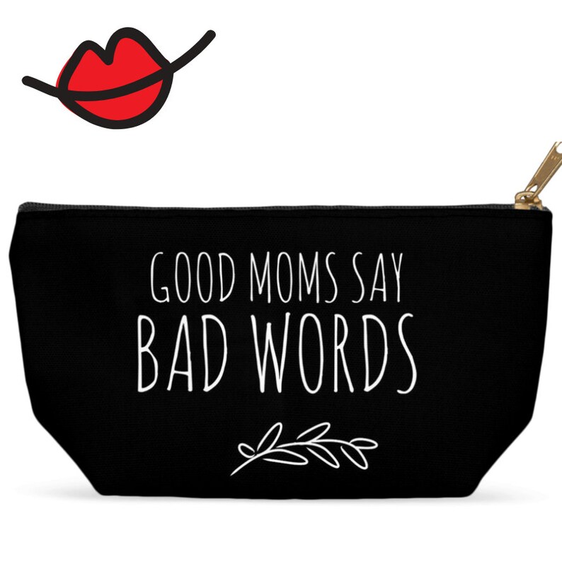 Puede incluir: Bolsa de lona negra con cremallera con texto blanco que dice "Good Moms Say Bad Words" y un peque&ntilde;o dise&ntilde;o floral blanco.