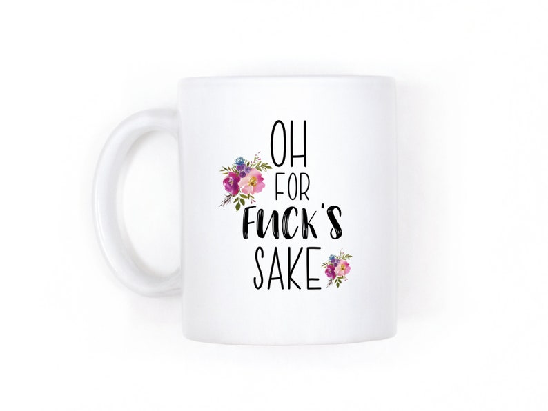 K&ouml;nnte beinhalten: Wei&szlig;e Keramik-Kaffeetasse mit einem schwarz-wei&szlig;en Design, auf dem "Oh for fuck's sake" steht. Die Tasse hat ein florales Design mit rosa, lila und gr&uuml;nen Blumen.