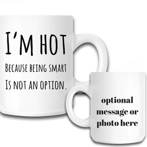 May include: White ceramic mug with black text that reads "I'M HOT BECAUSE BEING SMART IS NOT AN OPTION."  A smaller white mug with black text that reads "optional message or photo here" is shown to the right.