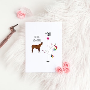 K&ouml;nnte beinhalten: Eine wei&szlig;e Karte mit einer humorvollen Illustration, die andere 40-J&auml;hrige mit einem Einhorn vergleicht, das einen Pole Dance macht. Der Text lautet "Andere 40-J&auml;hrige" und "Du".