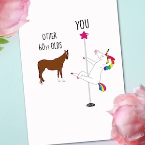 May include: A humorous greeting card with a white unicorn holding a pink star on a pole, with the text "YOU" above it.  The unicorn is wearing a rainbow tail and mane.  A brown horse is on the left side of the card with the text "OTHER 60 YR OLDS" above it.