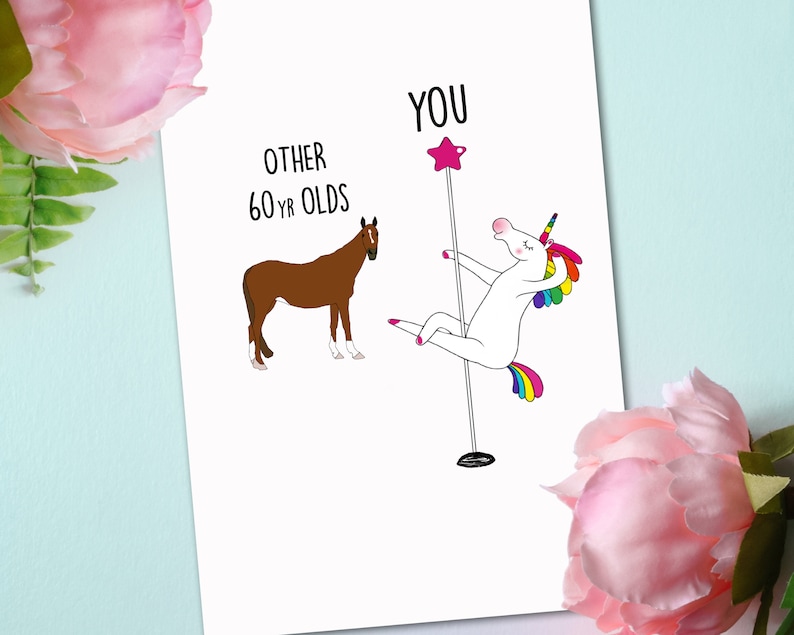 May include: A humorous greeting card with a white unicorn holding a pink star on a pole, with the text "YOU" above it.  The unicorn is wearing a rainbow tail and mane.  A brown horse is on the left side of the card with the text "OTHER 60 YR OLDS" above it.