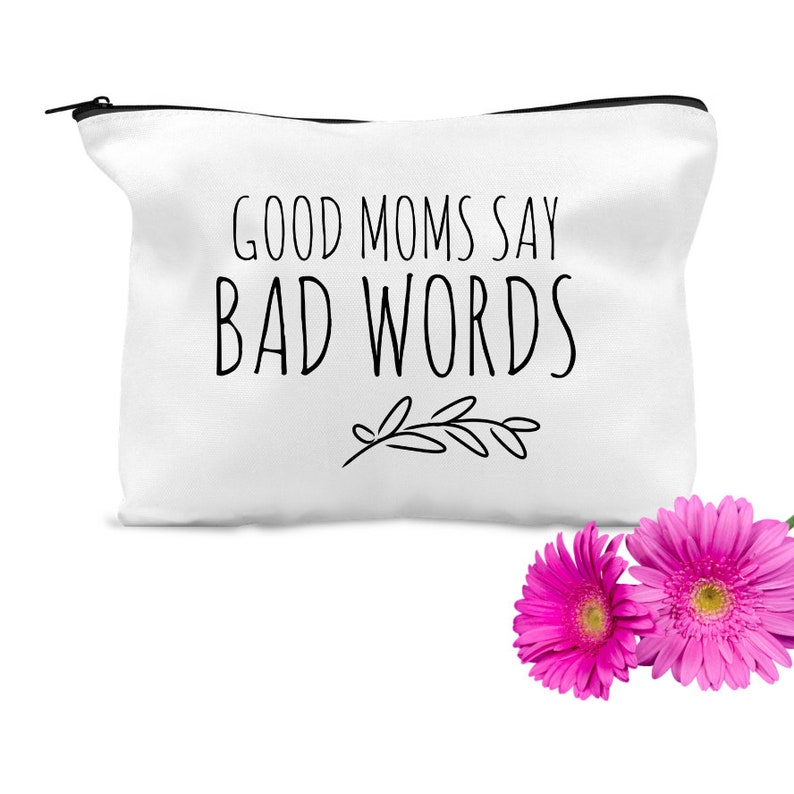 Puede incluir: Bolsa de maquillaje de lona blanca con texto negro que dice "Good Moms Say Bad Words" y un peque&ntilde;o dise&ntilde;o floral negro.
