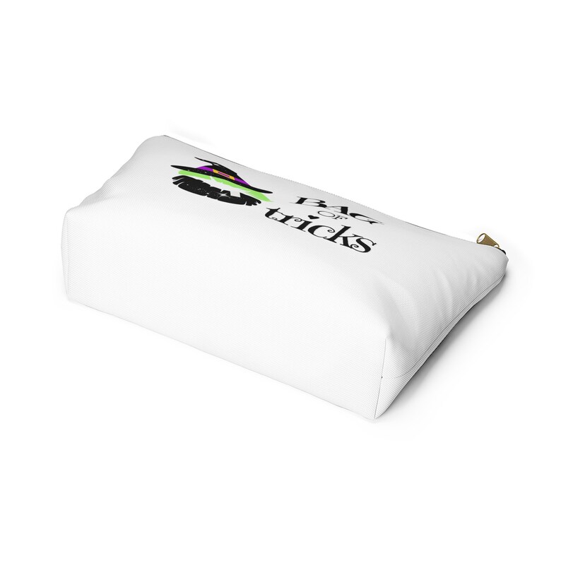 May include: White zippered pouch with a black and green witch graphic and the text "Bag of tricks".
