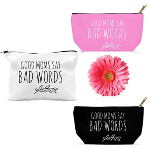Puede incluir: Tres estuches con cremallera con el texto "Good Moms Say Bad Words" en letras negras sobre fondo blanco, rosa y negro. Los estuches son todos del mismo tama&ntilde;o y forma.