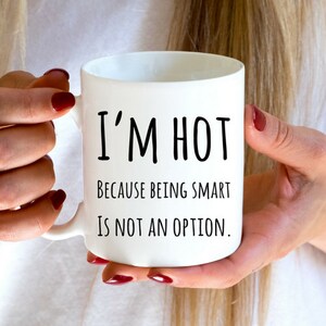 May include: White ceramic coffee mug with black text that reads "I'm hot because being smart is not an option."