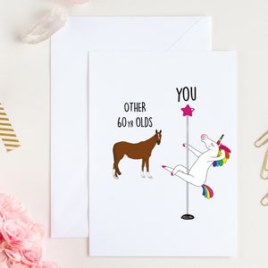 May include: A humorous birthday card featuring a unicorn doing a pole dance with the text "You" above it and "Other 60 yr olds" with a brown horse next to it.
