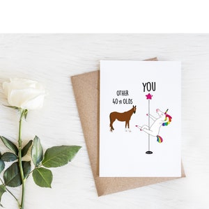 K&ouml;nnte beinhalten: Eine Gru&szlig;karte mit einem Einhorn, das an einer Stange tanzt, mit dem Text "YOU" dar&uuml;ber. Ein braunes Pferd befindet sich auf der linken Seite der Karte mit dem Text "OTHER 40 YR OLDS" dar&uuml;ber.