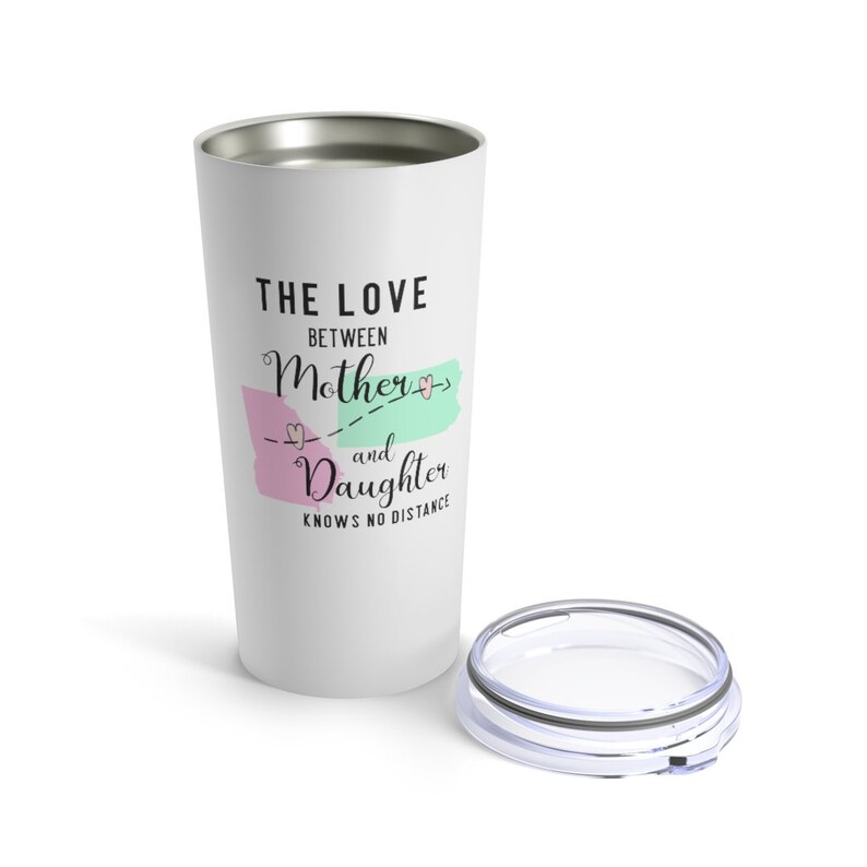 May include: White stainless steel travel mug with a pink and green design and the text "The love between mother and daughter knows no distance".