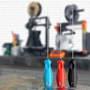 May include: Three 3D printer filament guides, one blue, one red, and one black, with the text "NoClogger" printed on each.