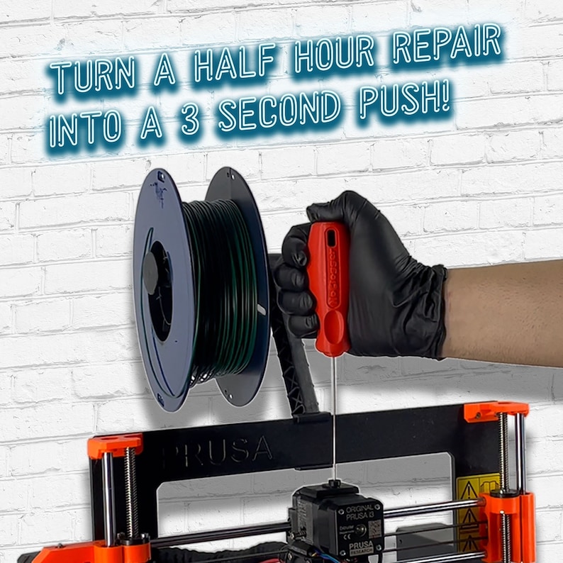 May include: A black 3D printer with a red and orange frame. A spool of green filament is mounted on the side of the printer. A gloved hand is using a red screwdriver to tighten a screw on the printer. The text "TURN A HALF HOUR REPAIR INTO A 3 SECOND PUSH!" is displayed above the printer. The text "PRUSA" is printed on the printer.