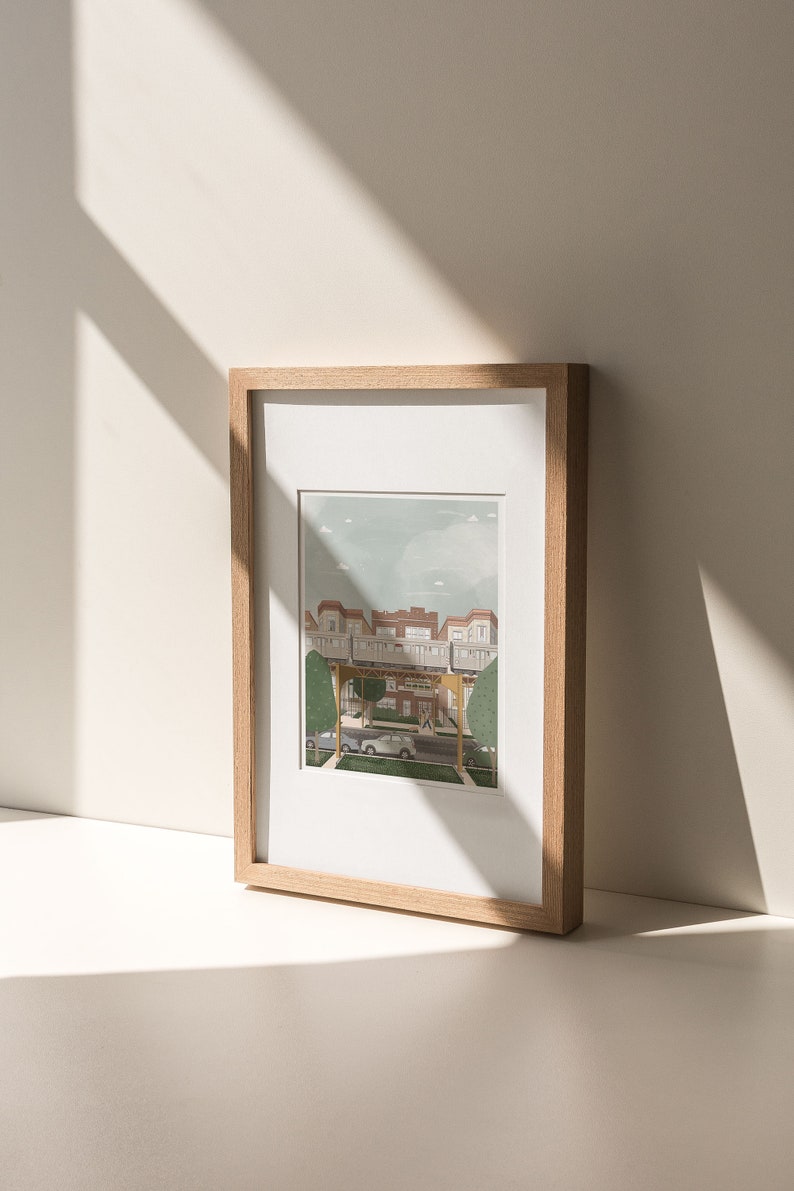 May include: A framed illustration of a city street with a train track overhead. The buildings are red brick and the street is lined with trees. There are two cars parked on the street and a person walking.