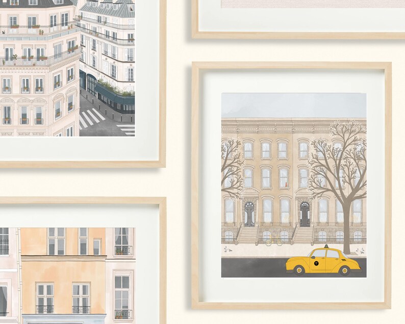 May include: A set of three framed illustrations of cityscapes. The first image shows a view of a Parisian street with buildings in the background. The second image shows a view of a New York City street with a yellow taxi cab in the foreground. The third image shows a view of a Parisian street with buildings in the background.