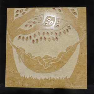 May include: A beige stone relief sculpture of a person lying in a hammock with a tree above. The tree has small, red and yellow leaves. The sculpture is signed "Clay Frazier".