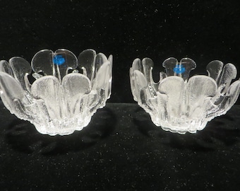 May include: Two clear glass bowls with a unique, organic, flower-like design. The bowls are made by Iittala and have a blue sticker on the bottom.