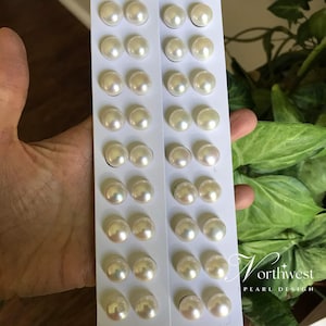 May include: A close-up of two white cards filled with round, off-white pearls. The pearls are arranged in rows. The Northwest Pearl Design logo is visible in the bottom right corner.