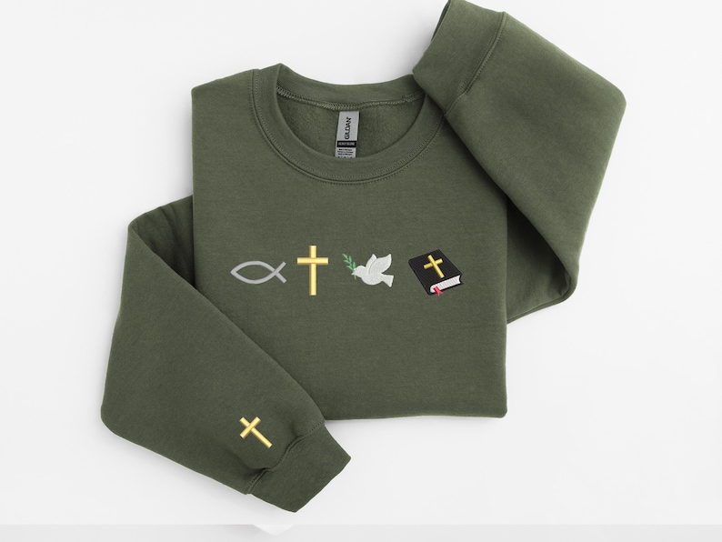 May include: A dark green sweatshirt with embroidered religious symbols, including a fish, a cross, a dove with an olive branch, and a closed book with a cross on the cover.