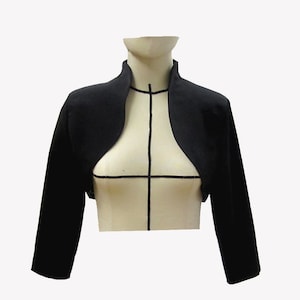 Könnte beinhalten: Ein schwarzer Bolero mit langen Ärmeln und einem runden Ausschnitt.