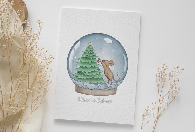 May include: A watercolor illustration of a snow globe with a mouse decorating a Christmas tree inside. The snow globe is on a white background with the text "Starcova Valeria" at the bottom.