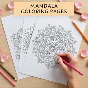 May include: Three black and white mandala colouring pages on a wooden surface. A hand is colouring one of the mandalas with a pink coloured pencil.