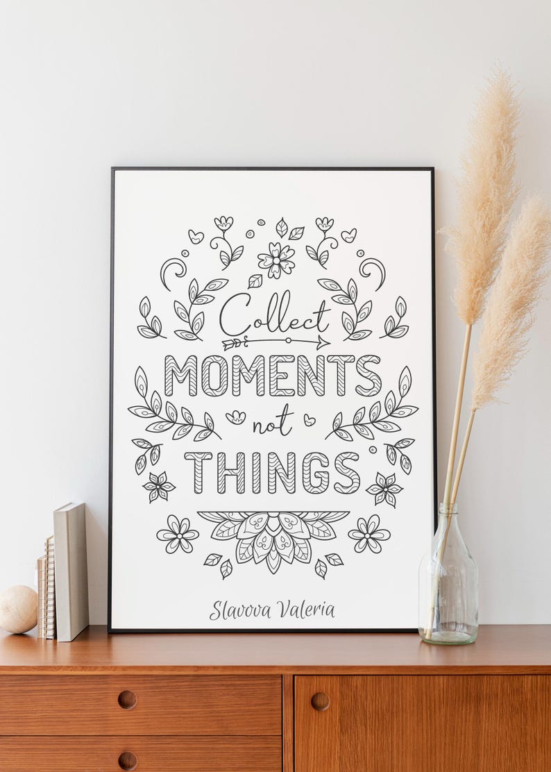 May include: Black framed art print with the words "Collect moments not things" in a decorative font, surrounded by floral and leaf illustrations. The artist's name, Slavova Valeria, is at the bottom.