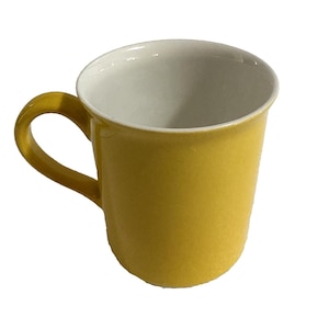 May include: A yellow ceramic mug with a white interior. The mug has a curved handle and a smooth, glossy finish. The mug is empty and sits against a white background.