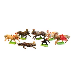 May include: A collection of vintage toy horses in various colors, including brown, tan, and black. Each horse is mounted on a green base and adorned with decorative saddles and riders. The toys are arranged in a dynamic, playful composition.