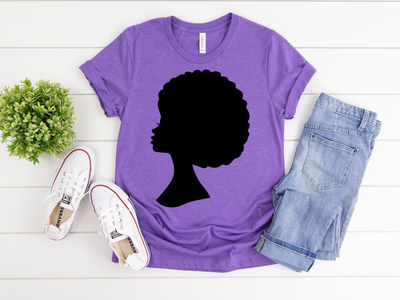 May include: Purple t-shirt with a black silhouette of a woman with an afro hairstyle.