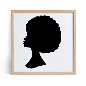 May include: A black silhouette of a person with an afro hairstyle in a light wood frame.