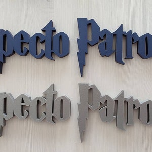 Może przedstawiać: Dwa zestawy słów "Expecto Patronum" w literach 3D. Jeden zestaw jest ciemnoniebieski, a drugi szary.