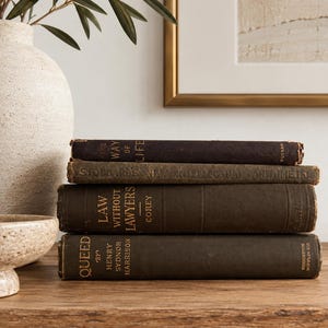 May include: A stack of four vintage hardcover books with dark brown and black spines. The titles include The Way of Life, Stoddard's New Intellectual Arithmetic, Law Without Lawyers by Corey, and Queed by Henry Sydnor Harrison.