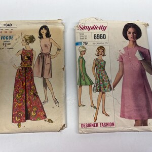 May include: Two vintage sewing pattern envelopes. One is Vogue 7049, featuring a woman in a paisley jumpsuit and a pink dress. The other is Simplicity 6960, with illustrations of women in dresses. The Simplicity pattern is labeled "Designer Fashion."