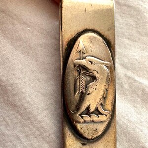 Porta billetes con forma de águila y flecha de Tiffany & Co. en plata, con motivo en relieve y monograma