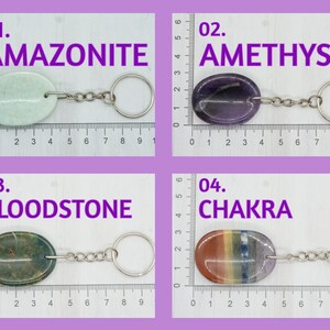 Op de afbeelding: Vier verschillende soorten edelsteen sleutelhangers. De sleutelhangers zijn gemaakt van amazoniet, amethist, bloedsteen en chakra stenen. Elke sleutelhanger is ovaalvormig en bevestigd aan een zilveren sleutelhanger ring.