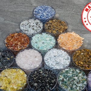 Peut inclure: Plusieurs petits récipients en verre remplis de verre concassé de différentes couleurs. Les couleurs comprennent le bleu, le blanc, le marron, le vert, l'orange, le noir, le jaune et le violet. Un autocollant rouge et blanc "Made in Canada" est visible.
