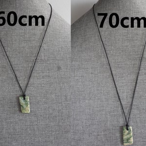 May include: Two necklaces with a green and white stone pendant. The necklace on the left is 60cm long and the necklace on the right is 70cm long.