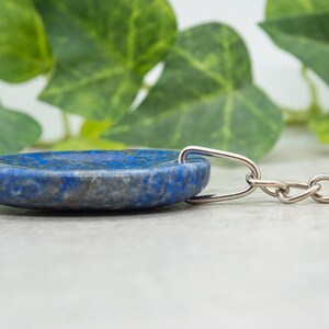 Op de afbeelding: Een blauwe lapis lazuli stenen sleutelhanger met een zilveren ketting.