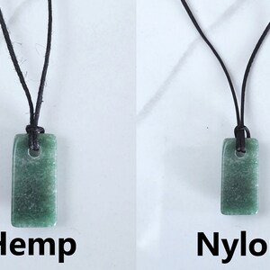 May include: Two green stone pendants on black cords. The pendant on the left is labeled "Hemp" and the pendant on the right is labeled "Nylon".