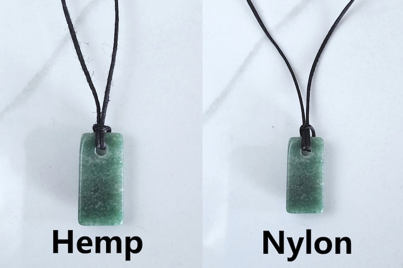 May include: Two green stone pendants on black cords. The pendant on the left is labeled "Hemp" and the pendant on the right is labeled "Nylon".