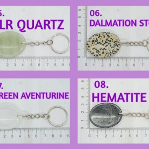 Op de afbeelding: Vier verschillende soorten stenen aan sleutelhangers. De stenen zijn gelabeld met "CLR QUARTZ", "DALMATION STONE", "GREEN AVENTURINE" en "HEMATITE".